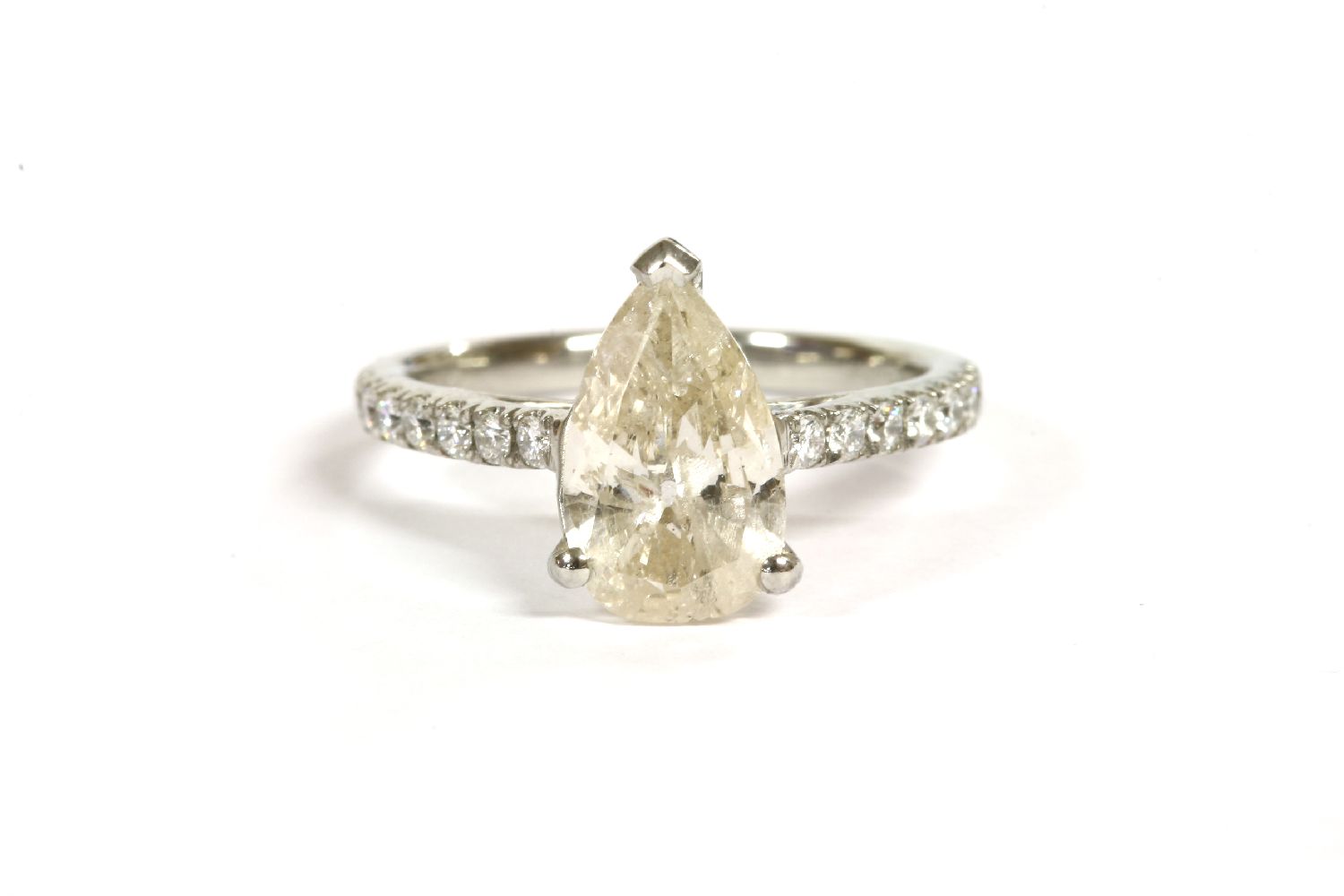 A platinum single stone pear shaped diamond ring, with diamond set shoulders, a pear shaped diamond,