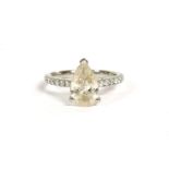A platinum single stone pear shaped diamond ring, with diamond set shoulders, a pear shaped diamond,