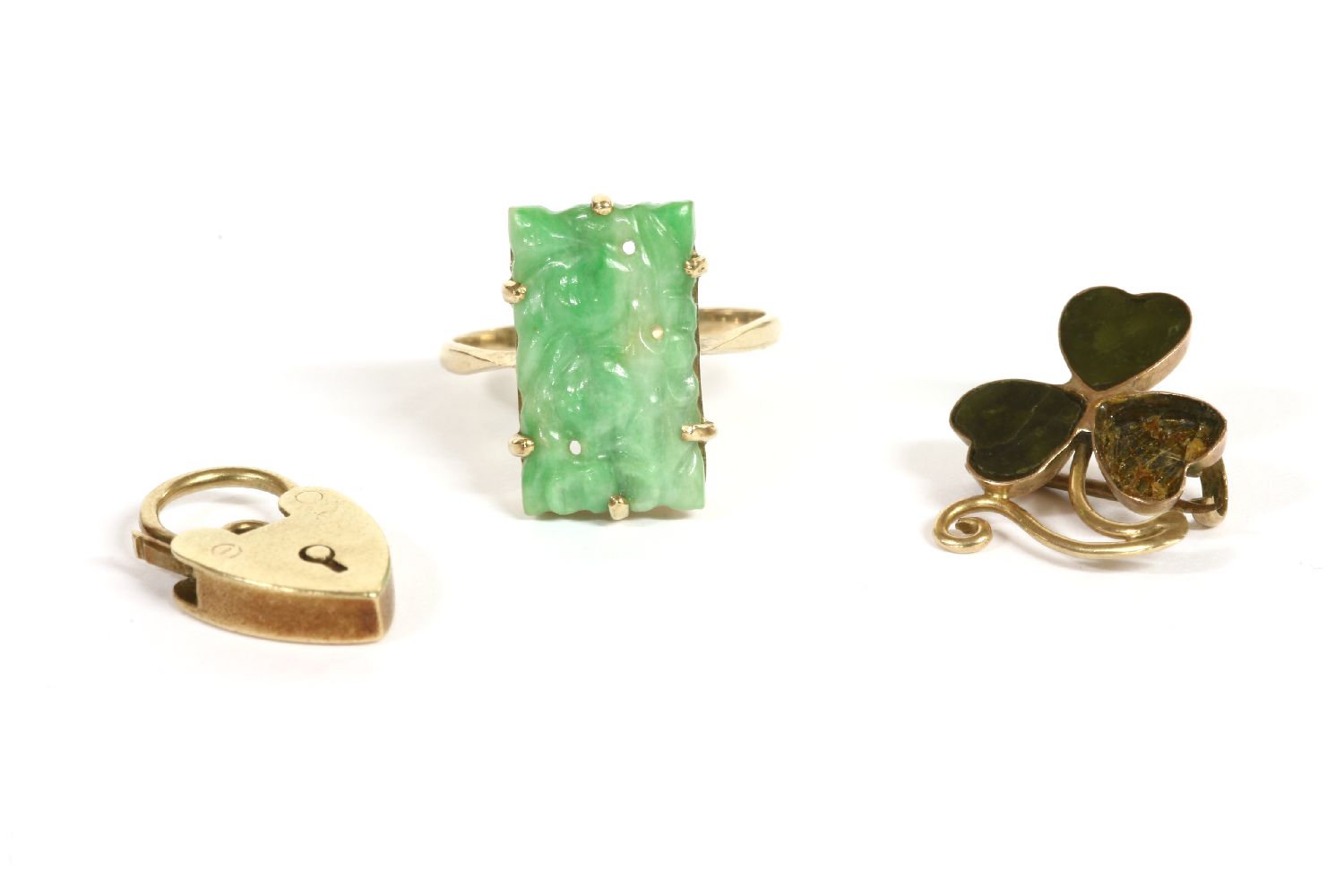 A gold carved jade plaque ring, marked 9ct, claw set, 2.84g, and a 9ct gold hardstone shamrock