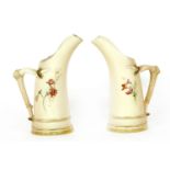 A pair of Royal Worcester 'blush ivory' ewers, decorated with flowers (a/f)