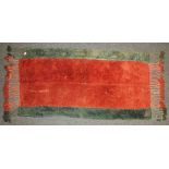 A Northern Afghanistan hand knotted woollen rug, the bold central red field flanked by blue stripes,