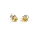 A pair of white gold single stone yellow sapphire earrings, marked 9k, colour M-N, tested as