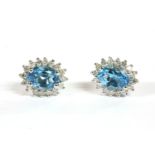 A pair of white gold topaz cluster earrings, an oval mixed cut topaz claw set to a cluster of