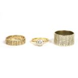 A 9ct gold wedding ring, bark textured set decoration with synthetic spinels, 3.83g, a 9ct white