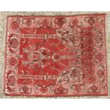 A hand knotted Persian prayer rug, the red fields with temple decorated centre within a wide