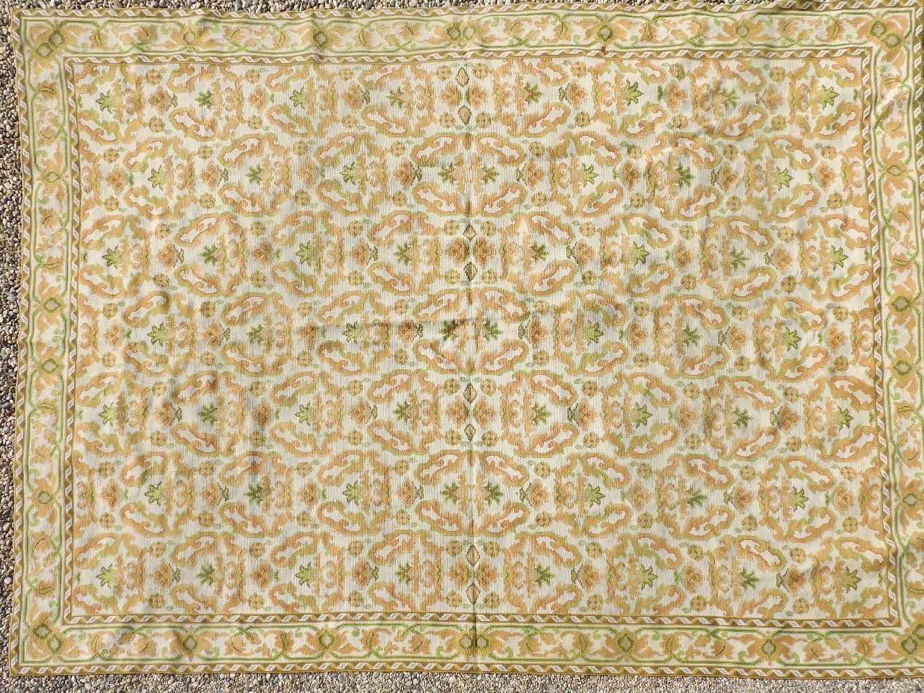 A 20th century Portuguese needlework rug, the cream ground with repeating foliate motifs, 274cm x