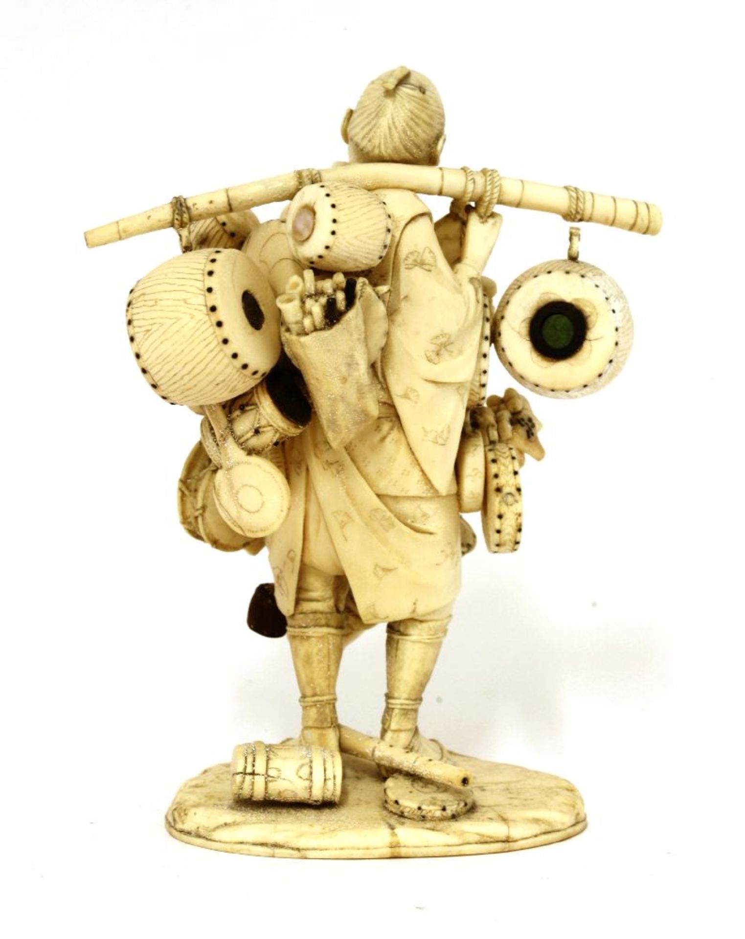 A Japanese ivory okimono,Meiji period (1868-1912), of a merchant carrying goods to sell, including - Image 2 of 3