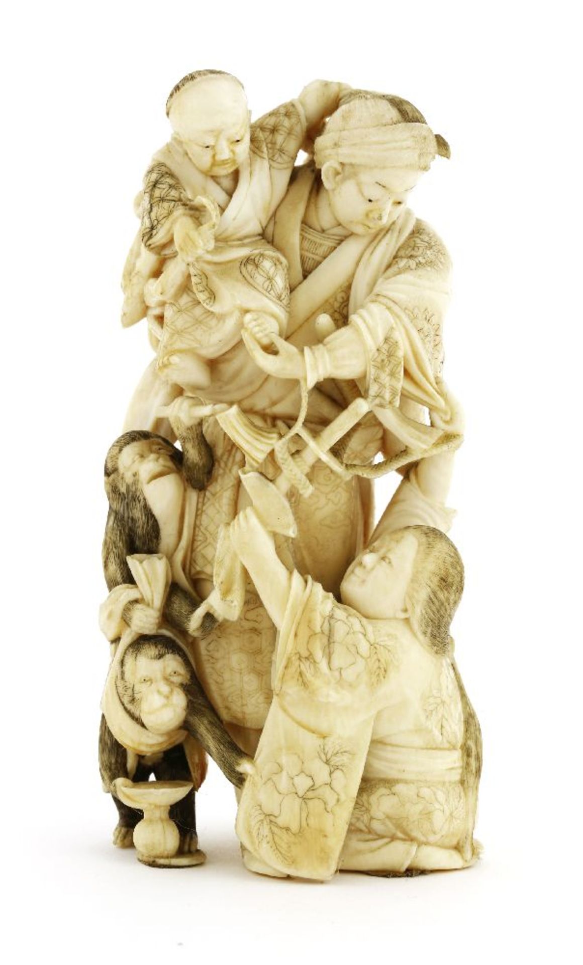 A Japanese ivory okimono,Meiji period (1868-1912), of a samurai holding a boy in his arms, a lady