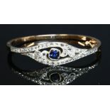 A Victorian sapphire and diamond crossover bangle, with a cushion cut sapphire, milligrain set to