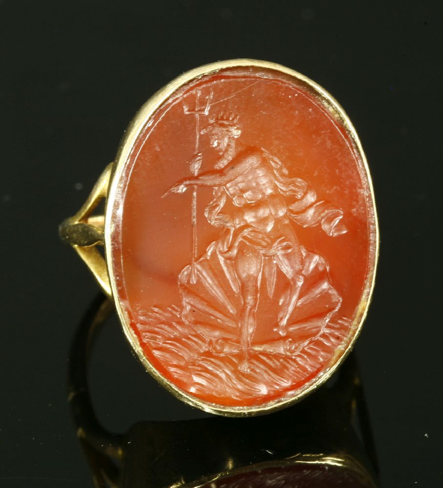 A gold intaglio engraved cornelian ring, with a flat oval cornelian tablet, intaglio engraved with