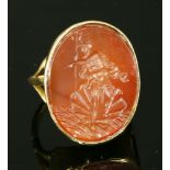 A gold intaglio engraved cornelian ring, with a flat oval cornelian tablet, intaglio engraved with