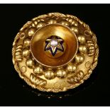 A Victorian gold shield-style brooch, c.1860,of circular form. A raised central boss with a split