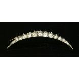 A late Victorian diamond crescent brooch, c.1890,with a row of graduated old European cut and old