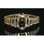 A French gold garnet set bracelet, c.1850,with an oval cabochon garnet, end set to the centre with