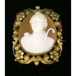 A gold carved shell cameo brooch, c.1830, set in a scrolling and floral openwork border,