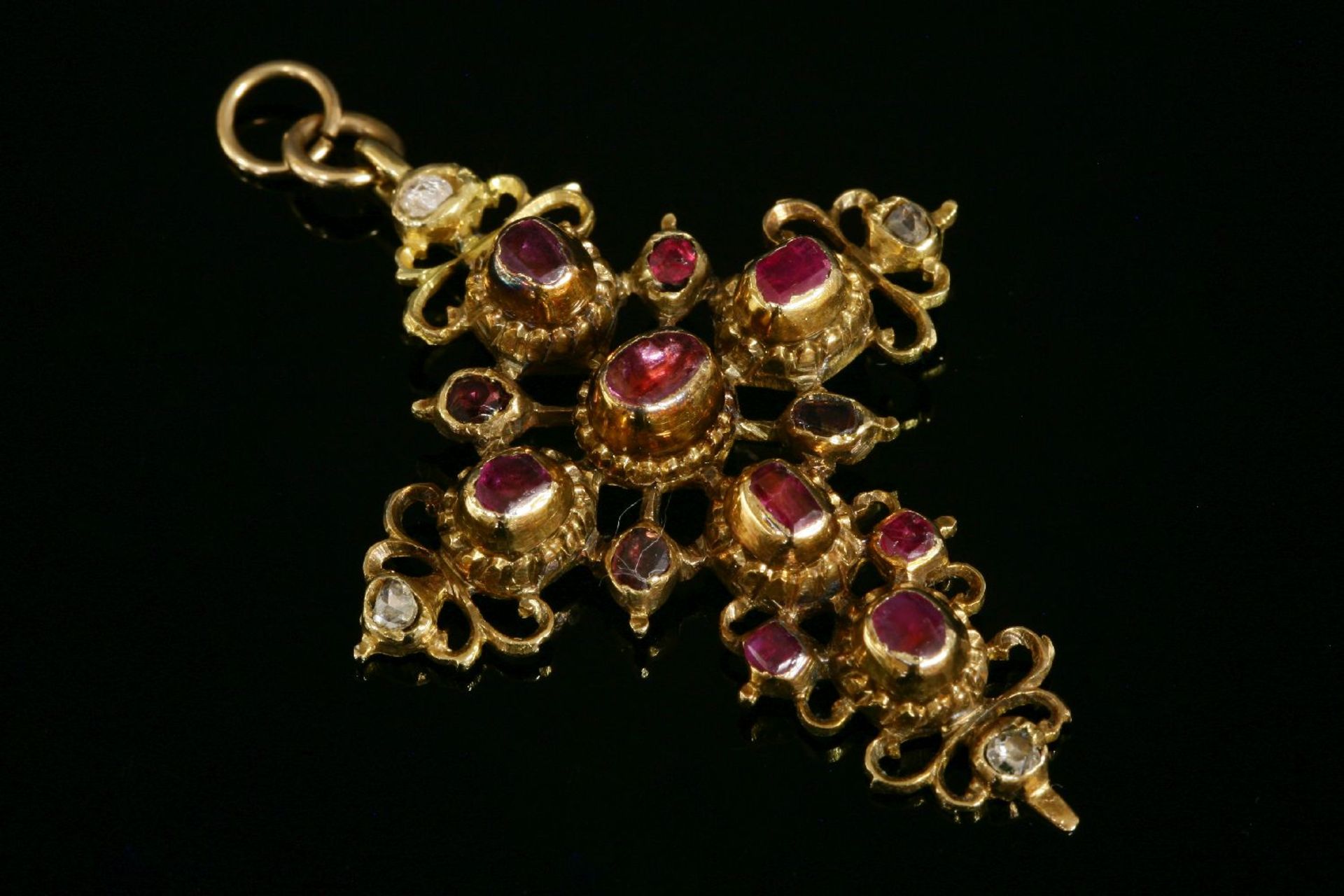 An Iberian gold, ruby and diamond set cross,with graduated foiled rubies rub set to plain collets,