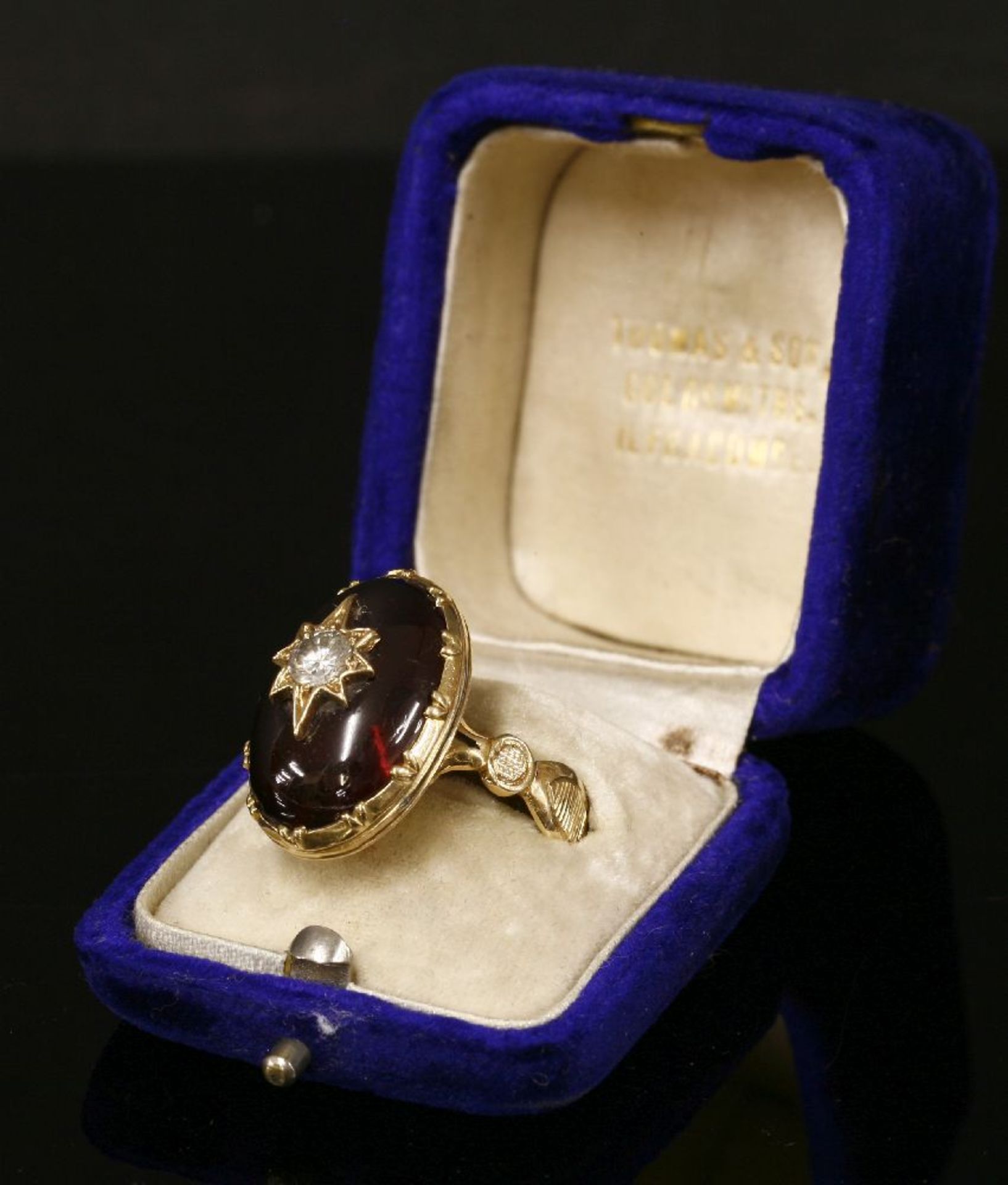 A diamond and garnet ring,with an old European cut diamond, grain set to a gold star, mounted to the - Image 2 of 2