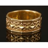 An 18ct gold Victorian chased band ring,of flat section diagonal form. A relief Gothic-style