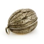 An apparently unmarked silver etui,in the form of a walnut, the hinged cover opening to reveal a