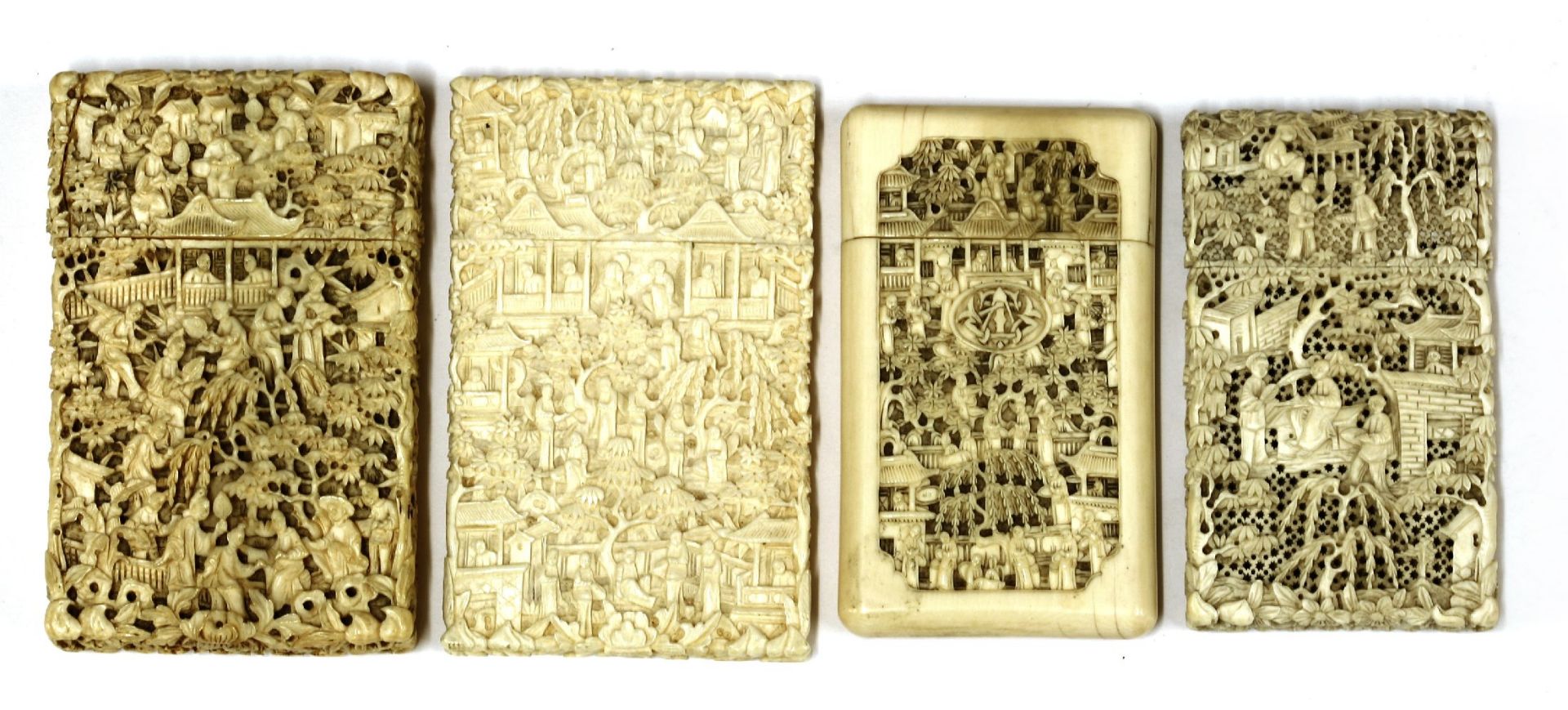 Four ivory cases, carved with figures in landscapes, pagodas, trees and foliage, one pierced,