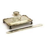 A single bottle inkstand,by Mappin & Webb, London, 1920,with a pen depression to the front,15.5cm