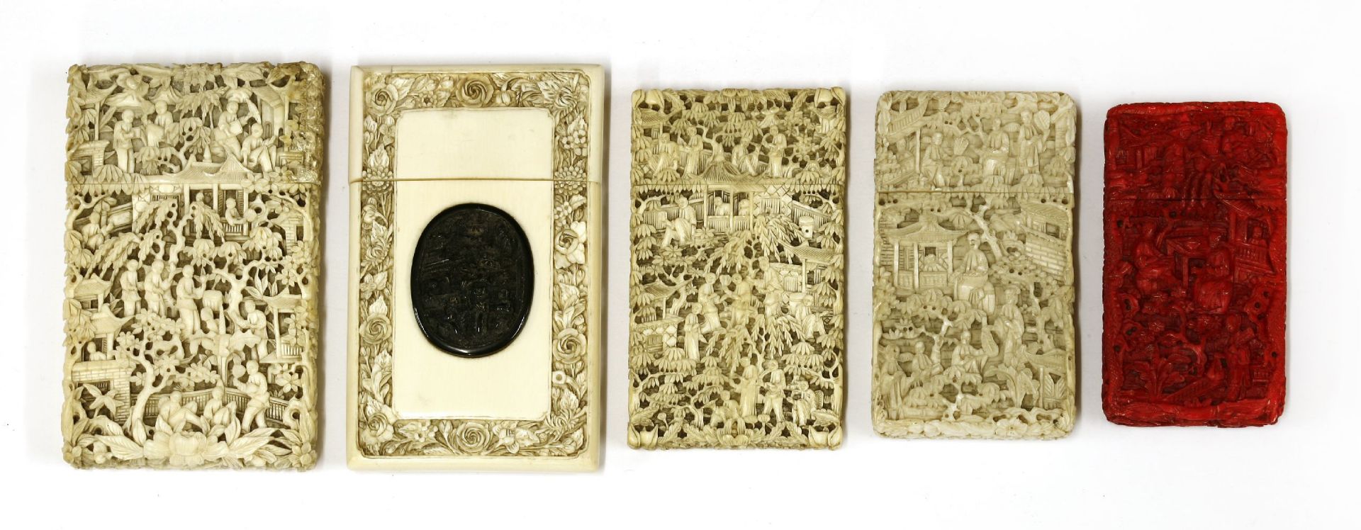 Five ivory cases, carved with figures in landscapes, trees, buildings and flowers, one red