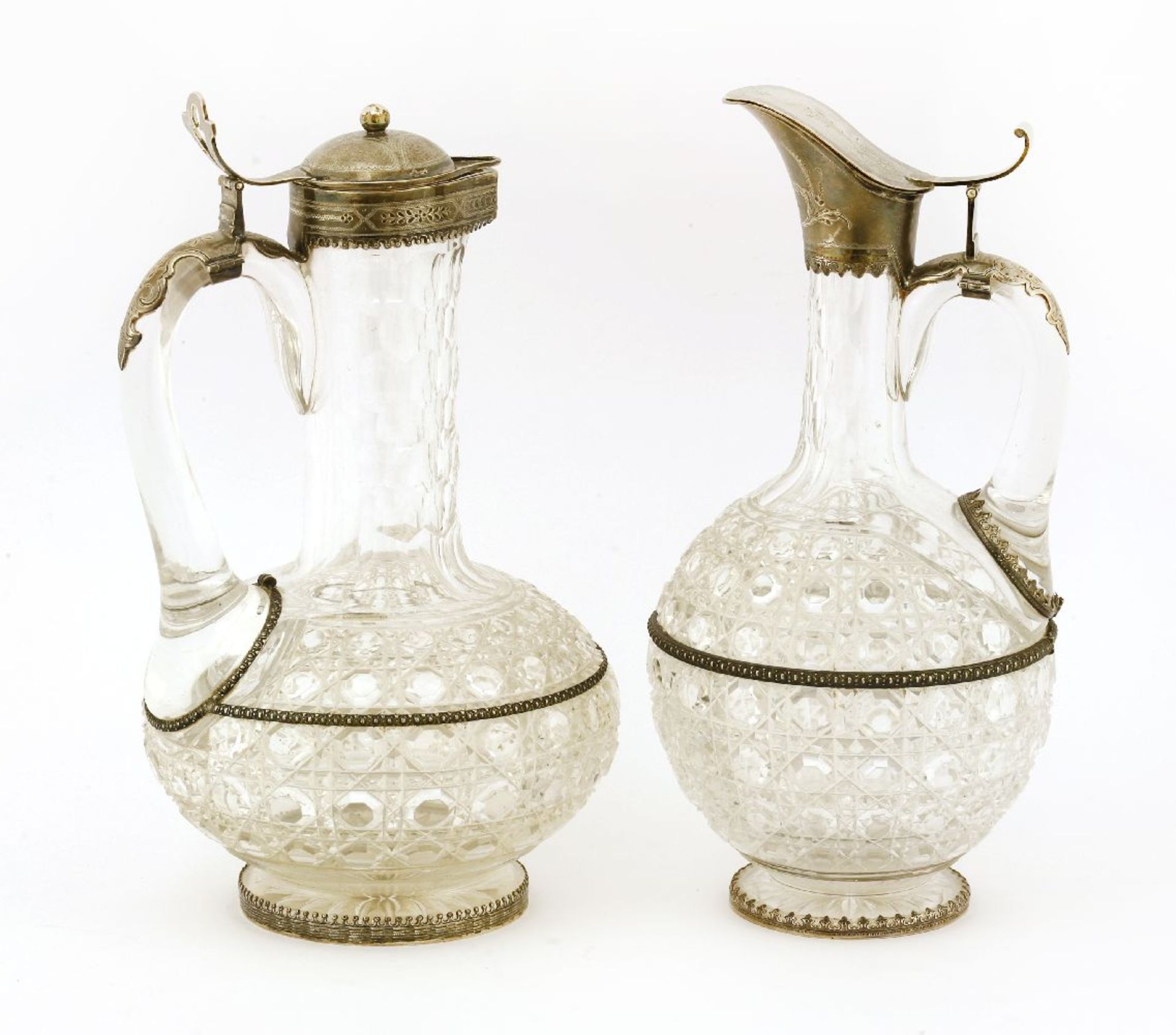 A near pair of mid-19th century German jug glass and silver-mounted claret jugs, the cut bodies of