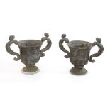 A pair of lead urns,in the 17th century style, with bold scrolled figural handles and moulded