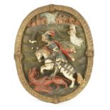 A German carved and painted oval panel,17th century, depicting St George slaying the dragon,