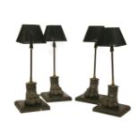 A set of four table lamps, each with a slender reeded support, on cast metal hairy paw feet and