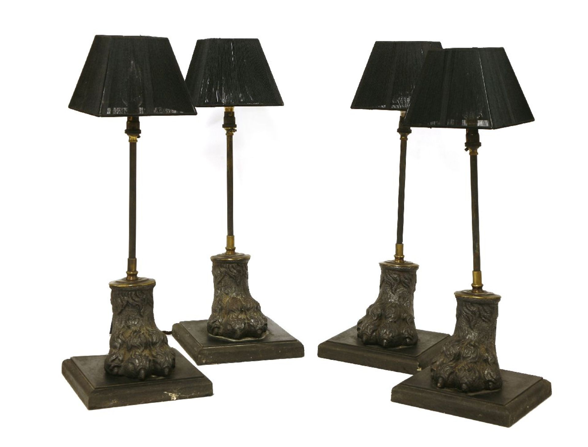 A set of four table lamps, each with a slender reeded support, on cast metal hairy paw feet and