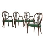 A set of four Hepplewhite-style mahogany elbow chairs, the oval backs with ornately carved splats