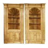 A pair of George III pine barrel-backed corner cupboards or alcoves, each with a fluted frieze