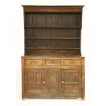 An oak dresser,18th century and later, the rack back over three drawers with cupboards beneath,144cm