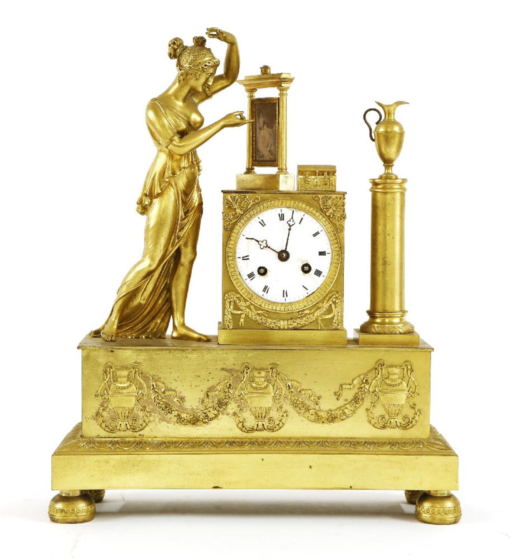 A large gilt metal mantel clock,late 19th century, with a white enamel dial flanked by a figural