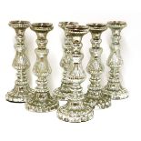 A set of six silvered glass candle stands,each of reeded baluster form and on lobed spreading