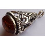 An ornate pierced silver Fob set with a cabouchon amber with inclusions,