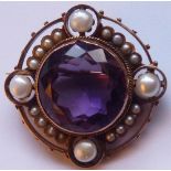 A late-19th century circular yellow metal Brooch centrally set with a pale hand-cut amethyst and