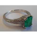 A ladies 18-carat gold Ring set with a 1 carat Columbian emerald and diamonds to the shoulders