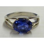A hallmarked platinum single-sapphire Ring set with an oval cornflower-blue sapphire measuring