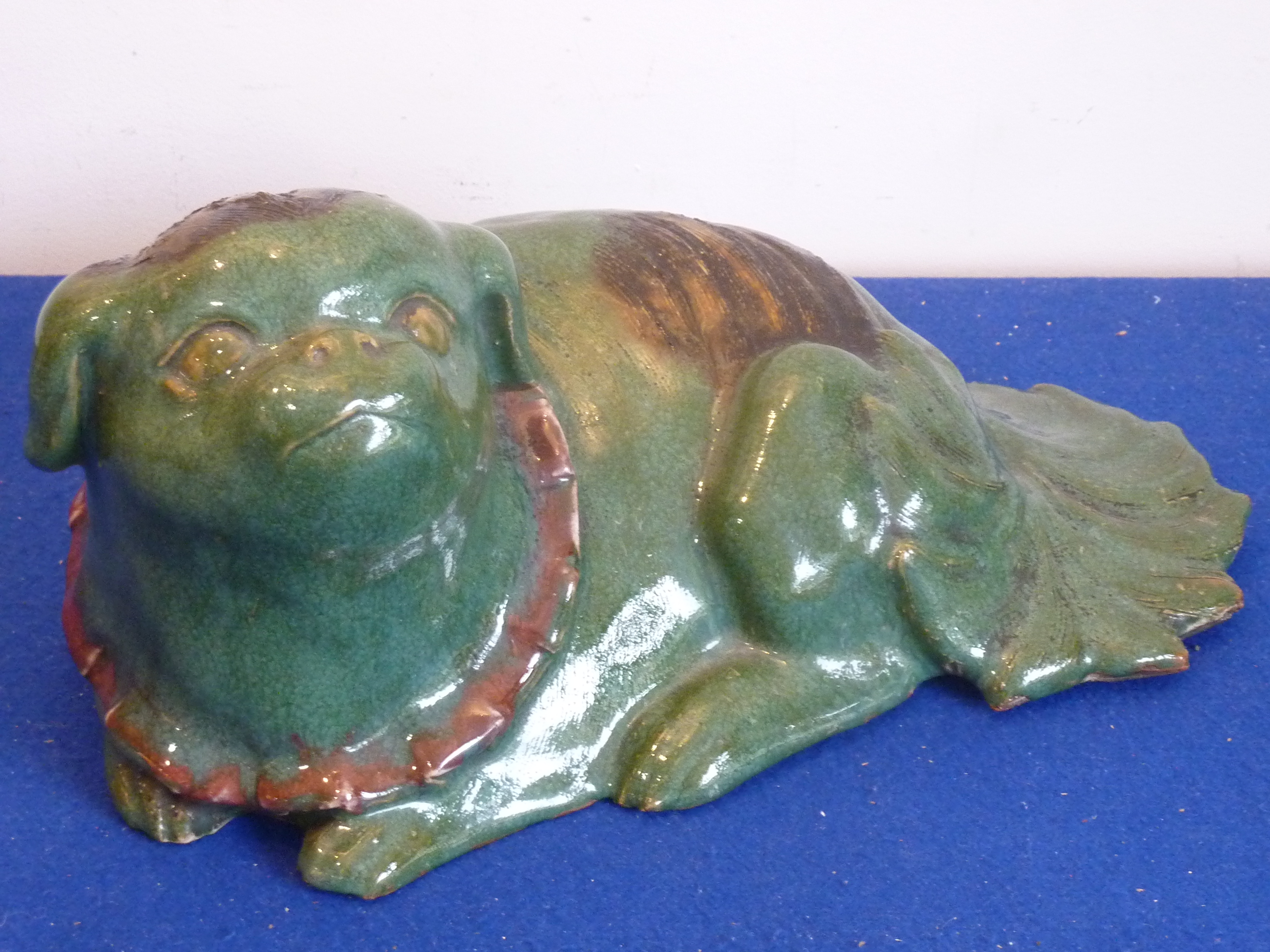 A green glazed Chinese ceramic Karashishi in recumbent pose,