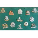 Thirteen regimental cap badges mounted on a display board: the North Staffordshire Regiment (Prince