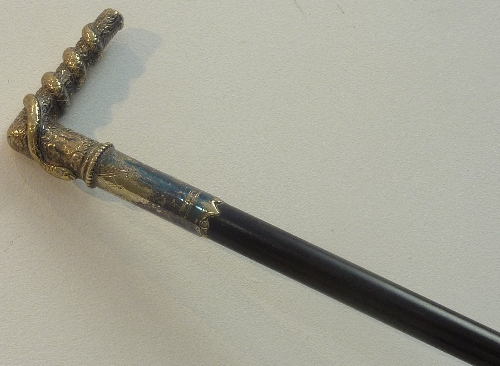 A late 19th century ebonised Walking Cane with a silver-plate mounted handle depicting a writhen