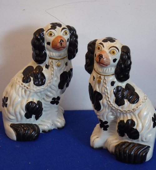 A pair of 19th century Staffordshire flat back black-and-white Spaniels, 25.