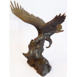 Wings of Glory, a 20th century patinated bronze of an open-winged eagle above rocks etc.