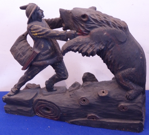 A Black Forest style wooden carving of a woodsman fighting a bear,