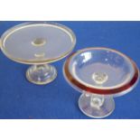 A clear glass tazza with ruby glass rim together with another slightly larger example with