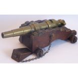 An interesting late 19th/early 20th century brass and patinated wood model of a cannon;