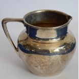 A hallmarked silver cream jug with angular handle; maker's mark C.E., assayed London 1928, approx.