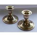 A pair of weighted sterling silver table candlesticks; signed to the underside Newport, Sterling, 7.